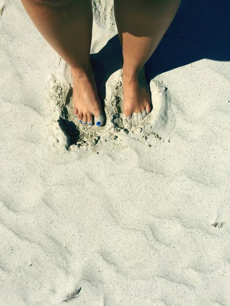 Foto seção baixa de homem na areia na praia