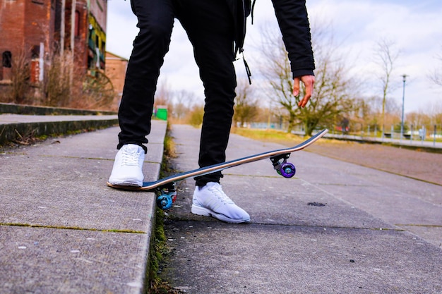 Seção baixa de homem patinando em uma trilha contra o céu