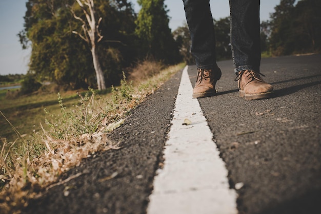 Seção baixa de homem usando sapatos na estrada