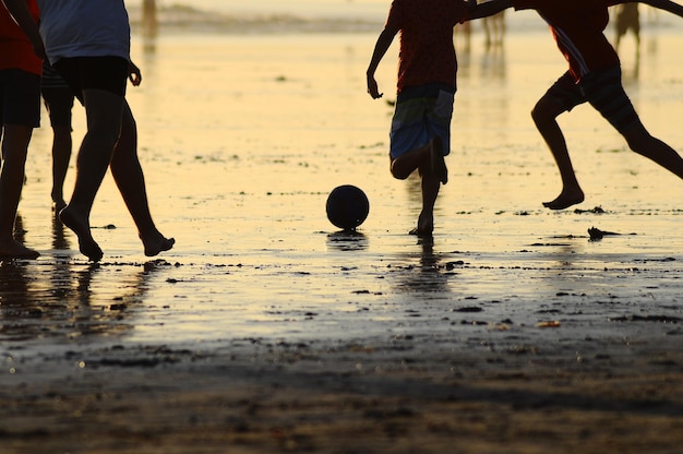 Foto seção baixa de meninos brincando na areia na praia