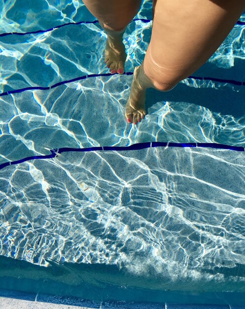 Foto seção baixa de mulher caminhando na piscina