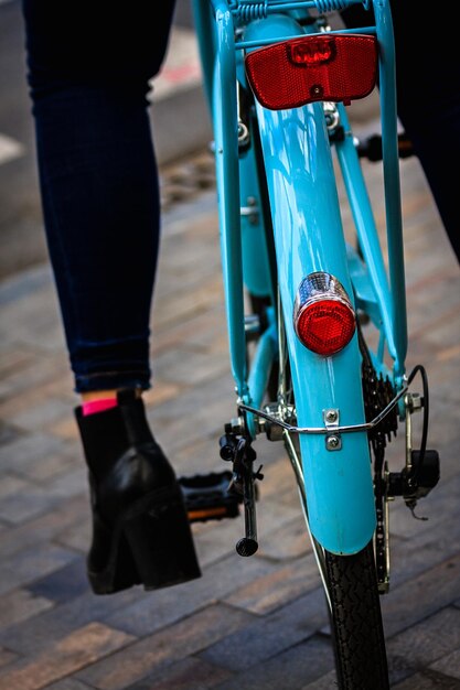 Foto seção baixa de mulher com bicicleta na rua