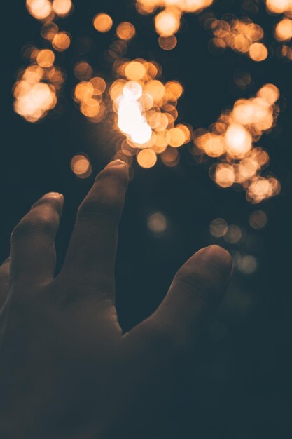 Foto seção baixa de mulher com luzes iluminadas contra o céu à noite