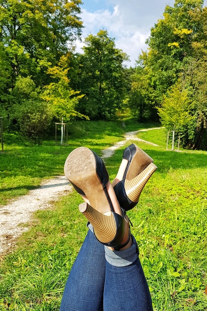 Seção baixa de mulher com os pés no campo gramado