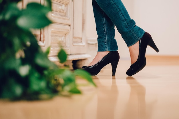 Seção baixa de mulher em jeans e sapatos de salto alto
