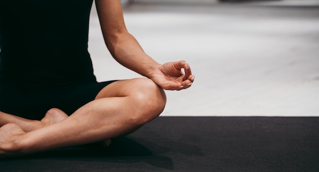 Seção baixa de mulher meditando no ginásio