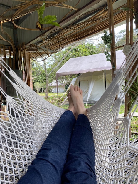 Foto seção baixa de mulher relaxando em uma hamaca