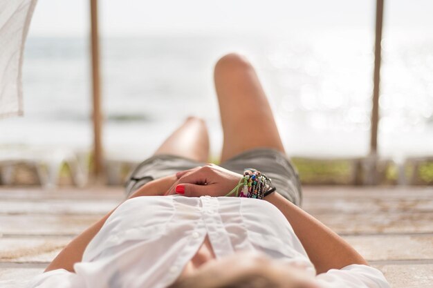 Foto seção baixa de mulher relaxando na praia