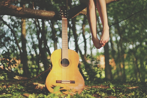 Foto seção baixa de mulher sentada com guitarra