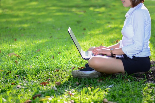 Seção baixa de mulheres usando laptop no campo