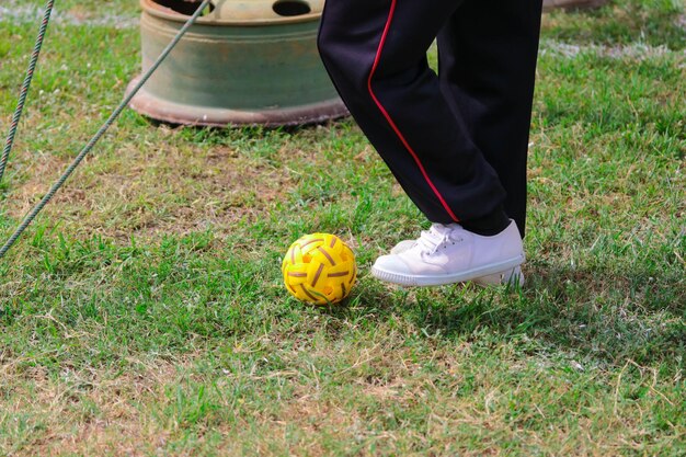 Foto seção baixa de pessoa caminhando com a bola no campo