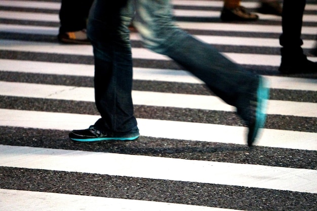 Foto seção baixa de pessoas a caminhar na passagem de pedestres