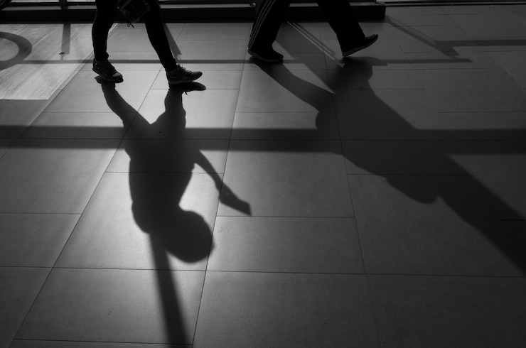 Foto seção baixa de pessoas caminhando no chão de telhas