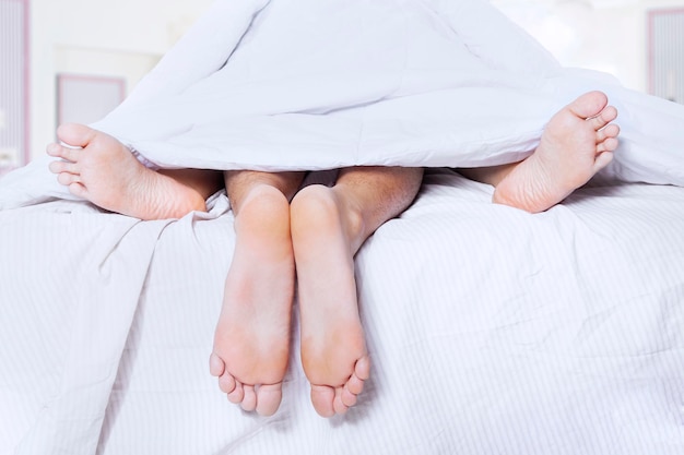 Seção baixa de um casal deitado na cama