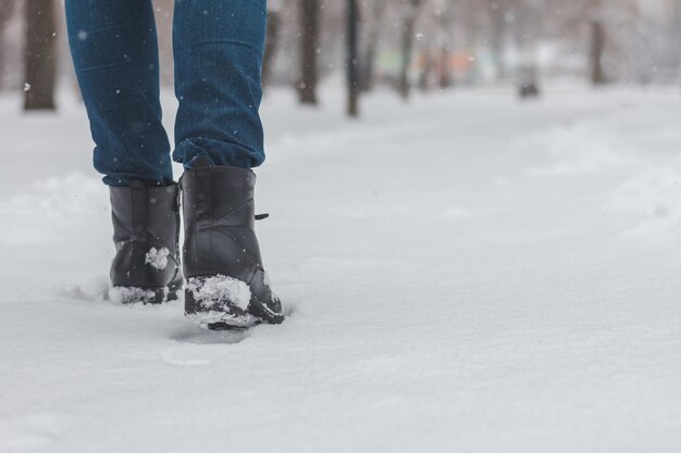 Seção baixa de um homem caminhando na neve