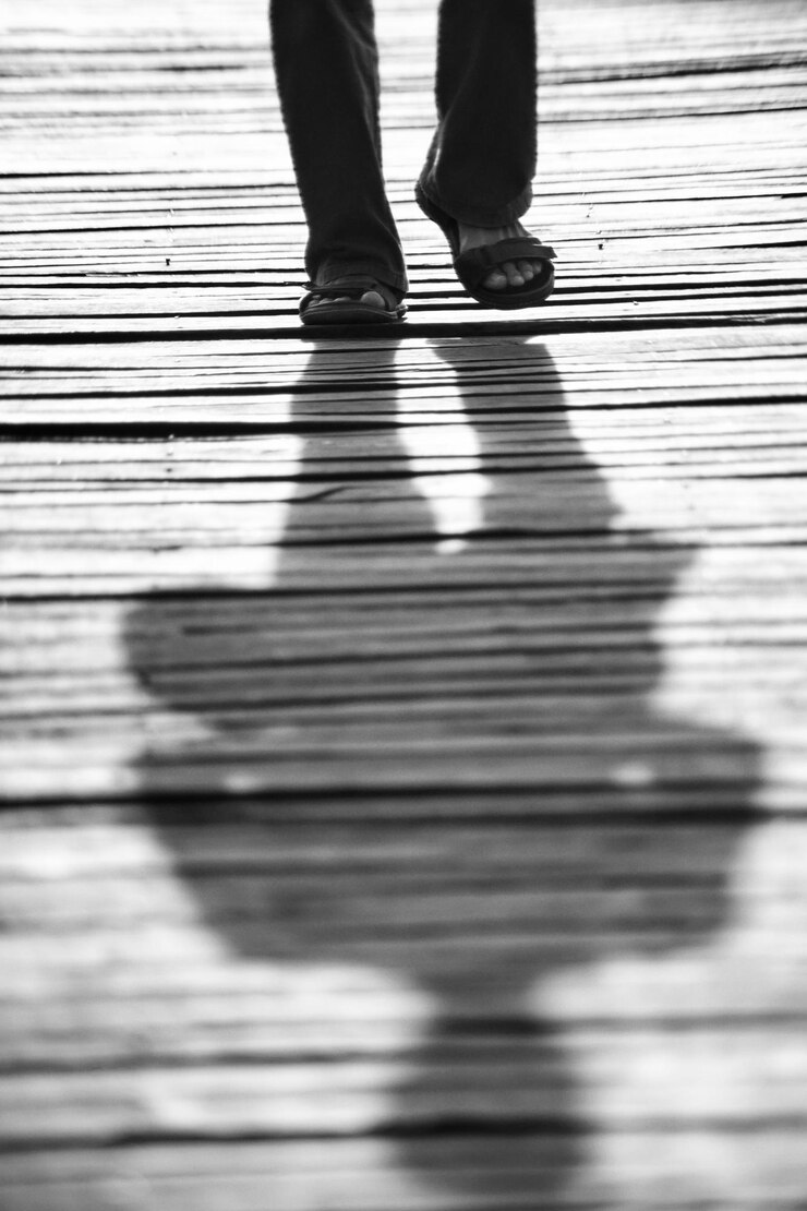 Foto seção baixa de um homem caminhando no calçadão