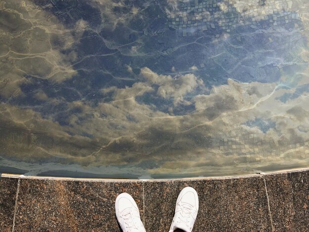 Foto seção baixa de um homem de pé à beira da piscina