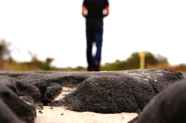 Foto seção baixa de um homem de pé em uma rocha