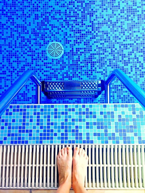 Foto seção baixa de um homem de pé junto à piscina