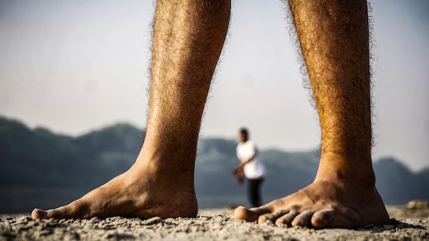 Foto seção baixa de um homem de pé na praia contra o céu