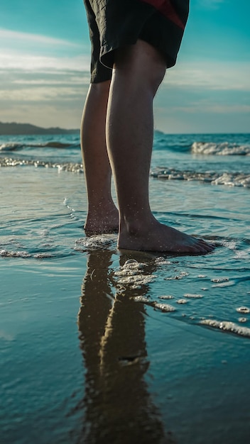 Seção baixa de um homem de pé na praia