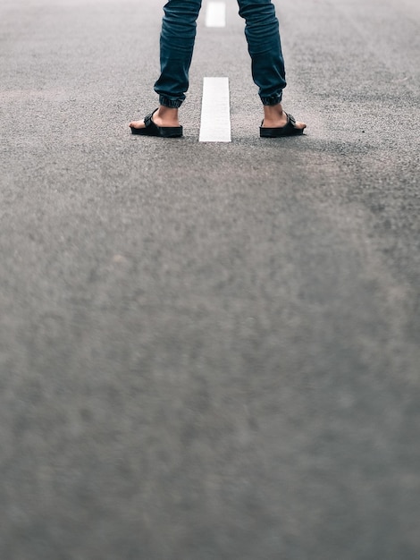 Seção baixa de um homem de pé no meio da estrada