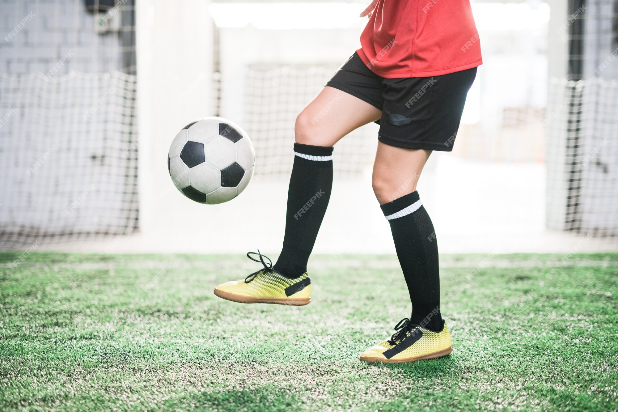 Seção baixa do jogador de futebol profissional que vai chutar a bola de  futebol de pé em um grande campo durante o jogo