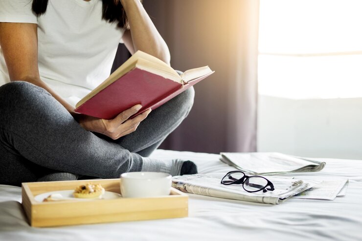 Foto seção baixa de uma mulher lendo um livro em casa