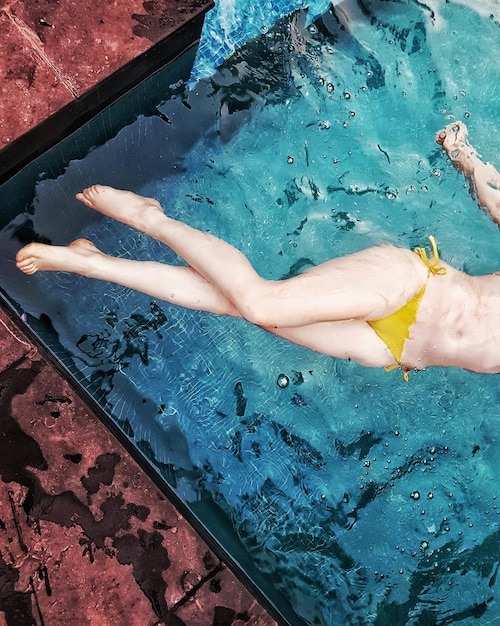 Seção baixa de uma mulher na piscina