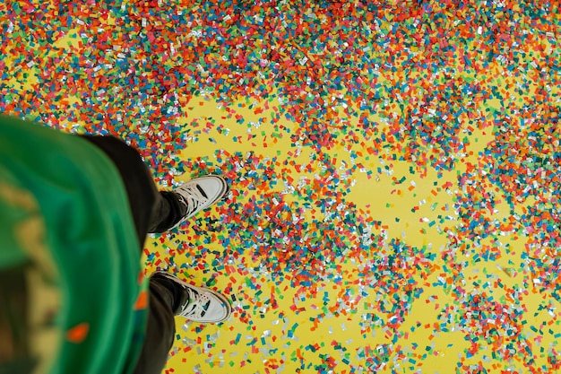 Foto seção baixa de uma pessoa de pé em confete multicolorido