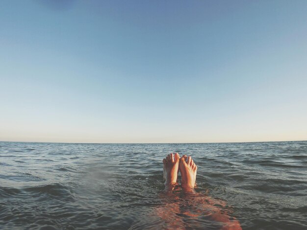 Seção baixa de uma pessoa no mar contra um céu claro