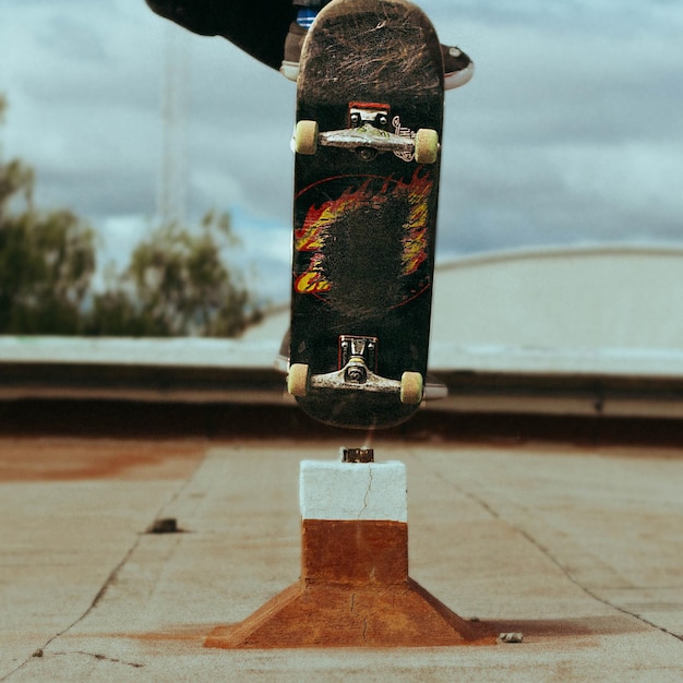 Foto seção baixa de uma pessoa realizando uma acrobacia em um skate