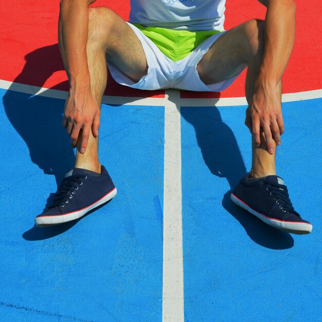 Seção baixa do atleta sentado no campo