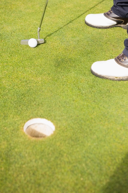 Seção baixa do homem jogando golfe