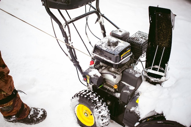 Foto seção baixa do homem limpando a neve com máquinas