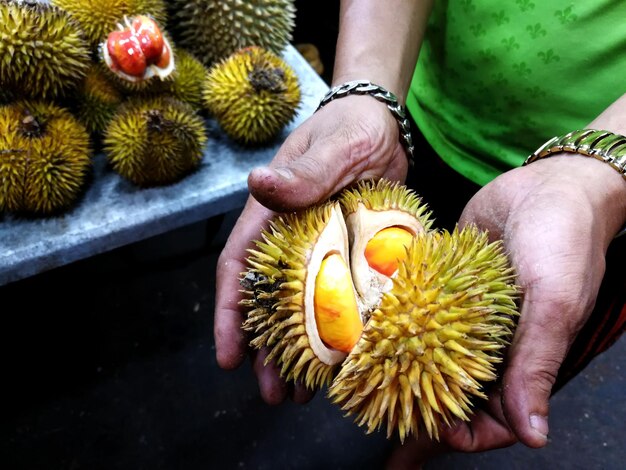 Foto seção central de um homem segurando frutas