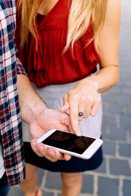 Seção do meio de um casal usando telefone móvel