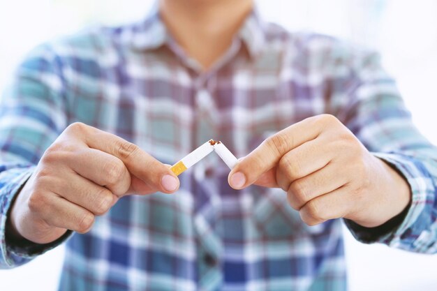 Foto seção do meio de um homem quebrando um cigarro