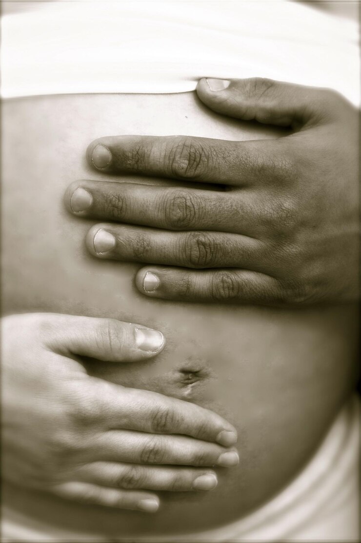 Foto seção do meio de uma mulher grávida com o marido tocando a barriga