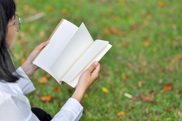 Seção do meio de uma mulher lendo um livro no campo