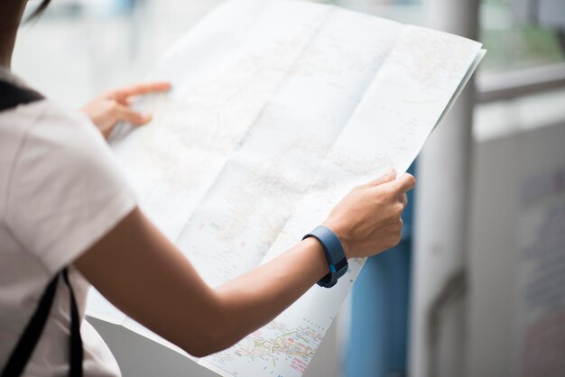 Foto seção do meio de uma mulher segurando um mapa na cidade