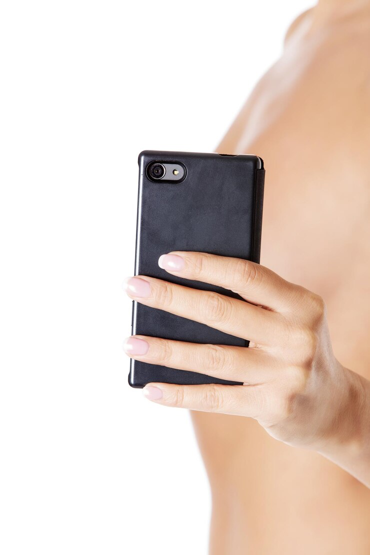 Foto seção do meio de uma mulher sem camisa segurando um smartphone contra um fundo branco