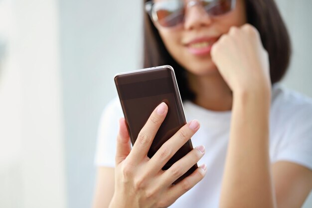 Seção do meio de uma mulher usando um telefone móvel