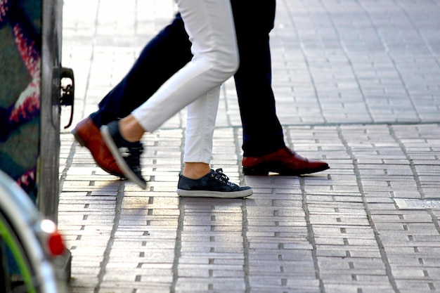 Foto seção inferior de homem e mulher andando na calçada