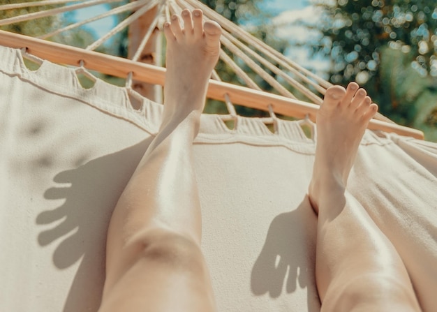 Seção inferior de uma mulher relaxando em uma rede