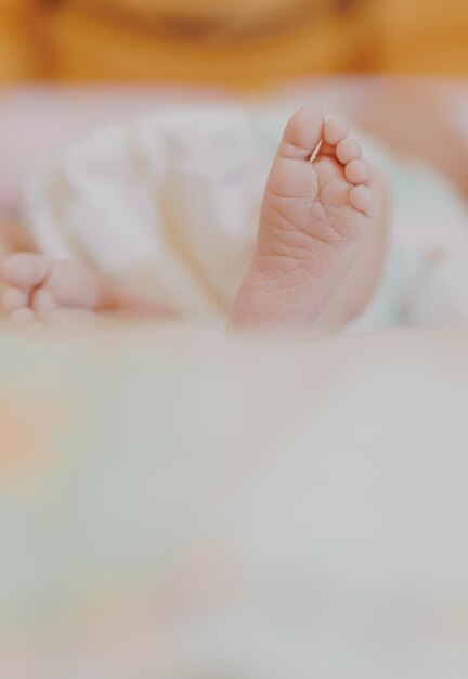 Foto seção inferior do bebê descansando na cama