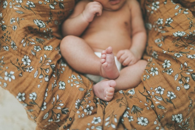 Seção inferior do bebé na cama em casa
