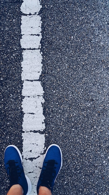 Foto seção inferior do homem de pé na estrada