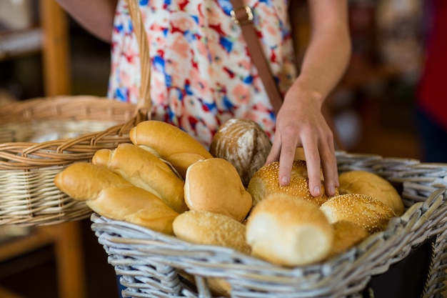 Seção intermediária da mulher selecionando pão