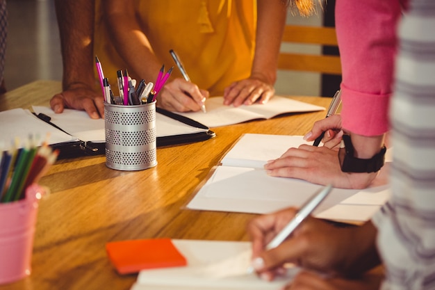 Seção intermediária de executivos de negócios, escrevendo no livro